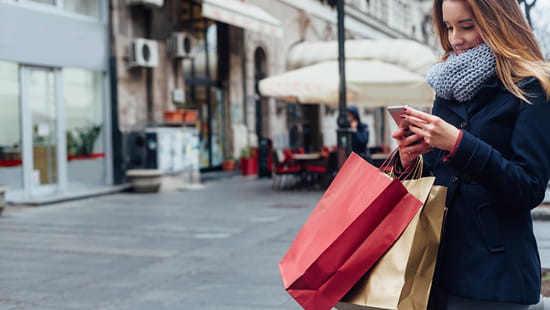Woman with shopping bags checking her phone